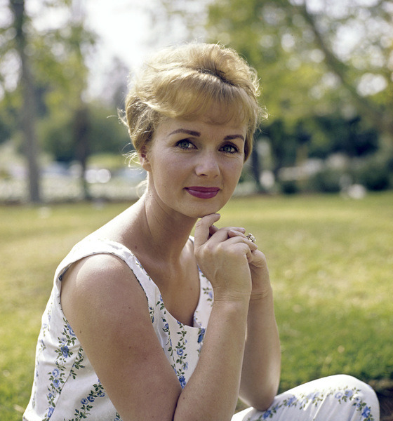 Debbie sitting  on the grass in a park, looking at the camera.